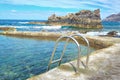 Scenic view of a metal ladder leading into a clear sea water pool with the Atlantic behind. Royalty Free Stock Photo