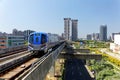 Scenic view of a metro train traveling on elevated rails of Taoyuan Airport MRT System and residential buildings clustering in bac