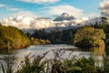 Scenic view on Mount Taranaki Mount Egmont in beautiful clouds over a forest and a lake Royalty Free Stock Photo