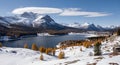 A scenic view of a mountain range with a lake in the foreground, surrounded by snow-covered trees Royalty Free Stock Photo