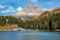 Scenic view of a mountain towering over colorful forest and calm lakefront hotel Royalty Free Stock Photo