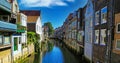 Scenic view on narrow dutch water canal with residential houses on both sides against blue summer sky - Dordrecht, Netherlands