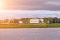 Scenic view of a old manor house by a river. Sun flare Royalty Free Stock Photo