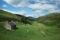 A scenic view with old scottish house, grazing sheep and a river flowing on the valley Royalty Free Stock Photo