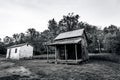 Scenic view of old wooden cabins on a grassy hill in grayscale Royalty Free Stock Photo