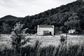 Scenic view of old wooden cabins on a grassy hill in grayscale Royalty Free Stock Photo