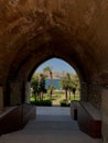 Stone arch framing view of palm tree and Bosphorus in Istanbul Royalty Free Stock Photo