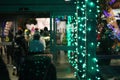 Scenic view of people entering a store decorated with colorful lights
