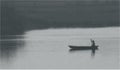 Scenic view photo of old vintage black and white rowboat in river or lake with man Royalty Free Stock Photo