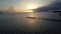 Scenic view of a pier settling into the horizon of a peaceful ocean at sunset