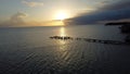 Scenic view of a pier settling into the horizon of a peaceful ocean at sunset