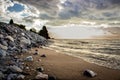 Scenic view of piled rocks near a shore under a gloomy sky background