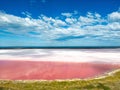 Scenic view of Pink Lake in Kalbarri, Port Gregory, Australia under a cloudy blue sky