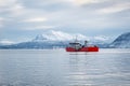 Scenic view of a red boat in a Norwegian fjord in winter Royalty Free Stock Photo