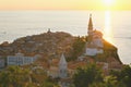 Scenic view of red roofs of the historical center of old town Piran with main church against the sunset . Royalty Free Stock Photo