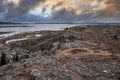 Scenic view of rock formations by lakes against cloudy sky during sunset