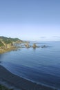 A scenic view of a rocky coastline, clear blue waters, and greenery under a bright sky Royalty Free Stock Photo