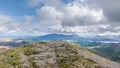 A scenic view of a rocky mountain summit with valley and mountain range in the background under a stormy grey cloudy sky Royalty Free Stock Photo