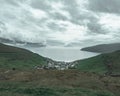 Scenic view of the rugged, natural landscape of the Faroe Islands with lush hills and fluffy clouds