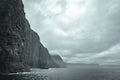 Scenic view of the rugged, natural landscape of the Faroe Islands with lush hills and fluffy clouds