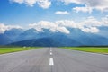 Scenic view of the runway road and mountain peaks in the clouds in the distance Royalty Free Stock Photo