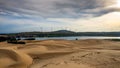 Scenic view of sand dunes against a lake and modern windmills in Mui Ne, Vietnam Royalty Free Stock Photo