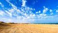 Scenic view of a sandy beach against the sea in United Arab Emirates under a cloudy blue sky Royalty Free Stock Photo