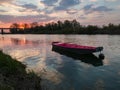 Scenic view of the Sava River in Bosanski Brod with a boat moored in front and the silhouette of a forest and a bridge in the