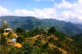 A scenic view of the Shan hills in Myanmar with wooden houses dotting the green slopes.