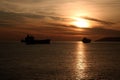 Scenic view of silhouettes of ships sailing in the sea at golden hour