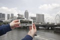 Scenic view of Singapore Hand with a smartphone, on the screen of which the urban landscape