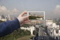 Scenic view of Singapore Hand with a smartphone, on the screen of which the urban landscape