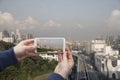 Scenic view of Singapore Hand with a smartphone, on the screen of which the urban landscape
