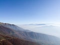 Scenic view of slopes of Vlasic mountain and Herzegovina mountains hidden in fog or smog in autumn during sunny day