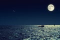 Scenic view of small fishing boat in calm sea water at night and