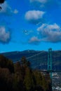 Scenic view of small sea plane flying over bridge and trees in harbor under blue sky Royalty Free Stock Photo