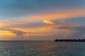 Scenic view on small villas on horizon under colorful clouds in sky during sunset in Indian ocean Royalty Free Stock Photo