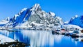 Scenic View of a snow rocky mountain and Rorbuer with reflections located along Gravdalsbukta. Lofoten Islands Norway Aurora