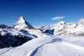 Scenic view on snowy Matterhorn peak in sunny day with blue sky and some clouds in background Royalty Free Stock Photo