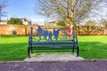 A scenic view of a soldier remembrance bench in a park along a path under a majestic blue sky