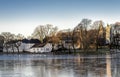 A scenic view of Stavanger city park lake frozen during winter months with seagulls and swans walking on ice early in the morning Royalty Free Stock Photo