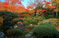 Scenic view of a stone lantern under fiery maple trees in the beautiful garden of Genkoan