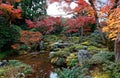 Scenic view of a stone lantern under fiery maple trees in the beautiful garden of Genkoan