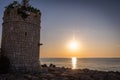 Scenic view of a stone tower on the beach against the sea at sunset Royalty Free Stock Photo