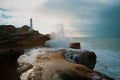 Scenic view of stormy breaking waves crashing against rock formations and Castlepoint Lighthouse Royalty Free Stock Photo