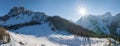 Sun shining over beautiful snow covered mountain range during winter Royalty Free Stock Photo