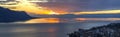 Scenic view of sunset over the Leman lake with yellow sky with clouds and Alps mountains in background, Montreux, Switzerland. Royalty Free Stock Photo