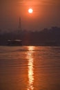 Scenic view of sunset and reflection with horizon.Greenery in background and lake in foreground with boat