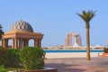 Scenic view to Abu Dhabi skyline with luxurious Fairmont Residences and decorative beach gazebo with palm tree