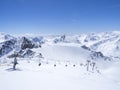 Scenic view from top of Wildspitz on winter landscape with snow covered mountain slopes and pistes and skiers on chair Royalty Free Stock Photo